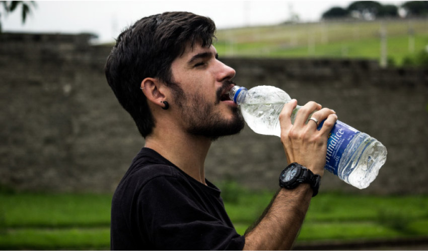 man drinking from a water bottle