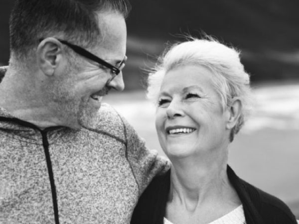 senior couple smile at each other after learning about dental crowns